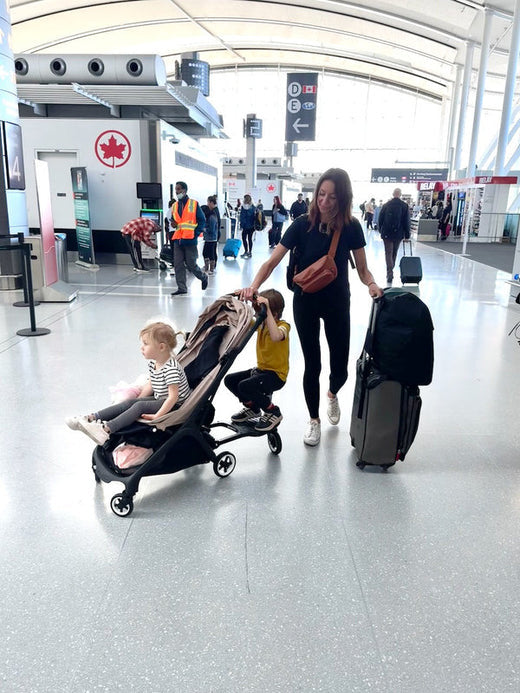 Olga at the airport with a travel stroller, buggy board and carry-ons