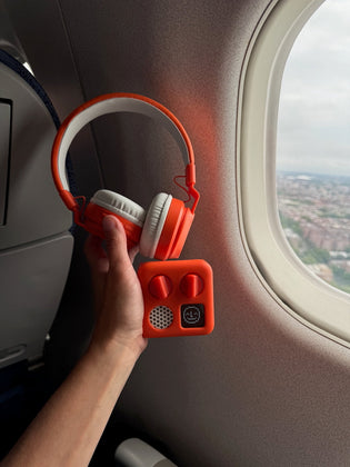  Yoto Mini device and headphones on airplane