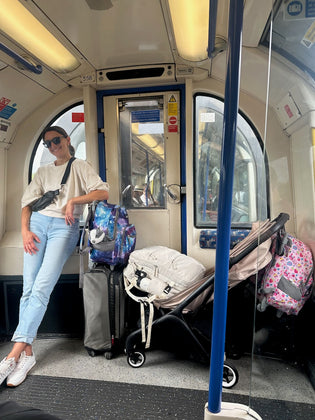  A mom on a train with lots of luggage and a stroller